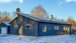 A single-story building with a sloped roof, a satellite dish, and a chimney.