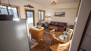 Una cocina compacta con zona de comedor, mobiliario de madera y vistas al exterior.
