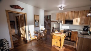 Una cocina amplia con armarios de madera, una zona de comedor con mesa y sillas, y vistas al área de estar.