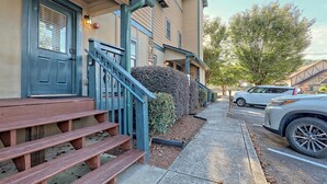 A residential building with a front porch, wooden steps, and a driveway. - Downtown Helen | Park and Walk (Helen)