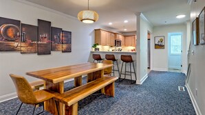 A modern kitchen with wooden cabinets, a central island, and bar stools. - Downtown Helen | Park and Walk (Helen)