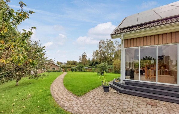Una casa moderna con entrada de puerta de cristal y camino de entrada pavimentado.