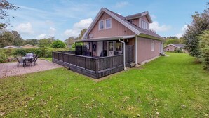 A two-story house with a covered porch and a fenced backyard.