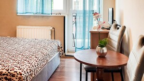 A hotel room with a bed, a desk with a computer, a chair, and a window with curtains. - 3 bedroom lovely apartment in Wiselka (Wiselka)