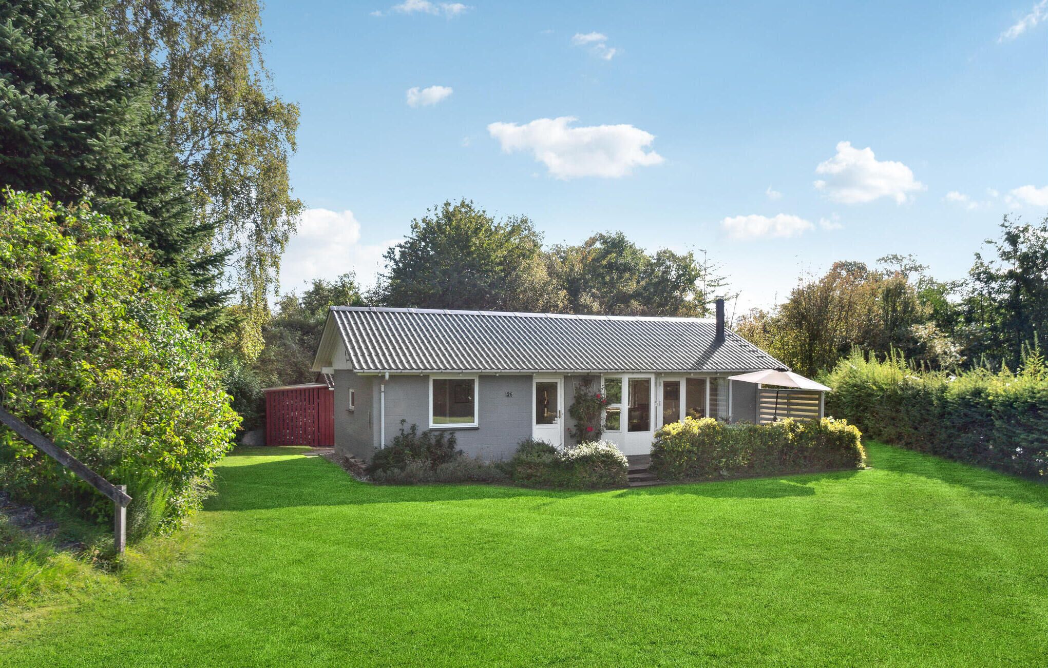 A single-story house with a sloped roof, a front porch, and a well-maintained lawn.
