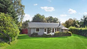 A single-story house with a sloped roof, a front porch, and a well-maintained lawn.