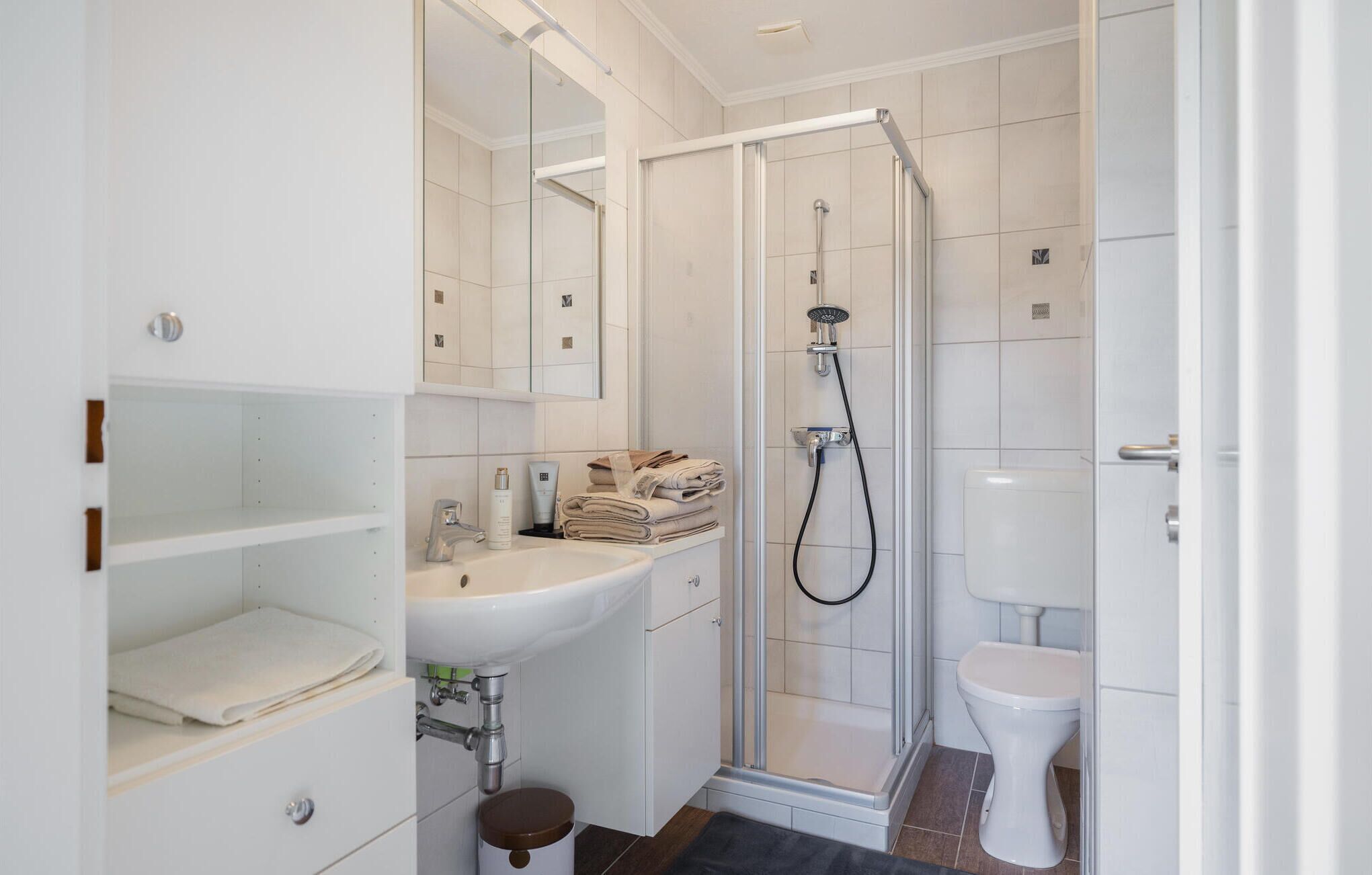 Une salle de bain moderne avec une douche à parois de verre, des toilettes et un lavabo.