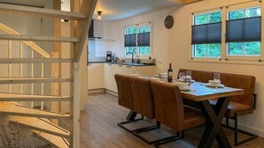 A dining area with a wooden table and chairs, a kitchen in the background, and a staircase. - Gorgeous home in Marienberg with WiFi (Marienberg)