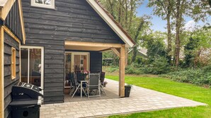 A house with a covered patio area featuring a table and chairs, a grill, and a garden with a lawn and trees. - Gorgeous home in Marienberg with WiFi (Marienberg)