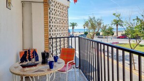 Un balcón con una mesa, sillas y un modelo decorativo de un velero.