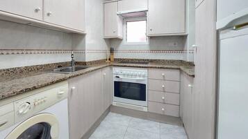 Een koelkast, een oven, een kookplaat, een koffiezetapparaat/waterkoker