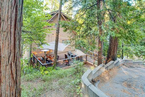 A lodge with a deck, outdoor seating, and a stone retaining wall. - 1 Mi to Lake Arrowhead Village! Cabin w/ Game Room (Lake Arrowhead)