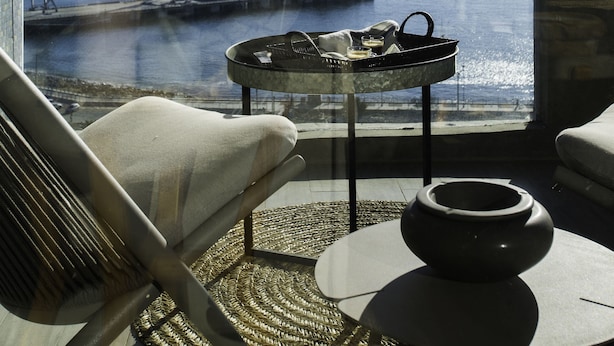 A balcony with a view of a harbor, a table with a pot, and a chair. - Departamento B Vista Privilegiada Cerro Barón (Valparaíso)