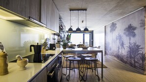 A modern kitchen with a central island, bar stools, and a large window. - Departamento B Vista Privilegiada Cerro Barón (Valparaíso)