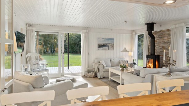 A cozy living room with a fireplace, a sofa set, and a dining table.
