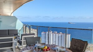 A dining area with a table set for four, overlooking the ocean. - SUNSET WAVES WoW apartment (Benidorm)