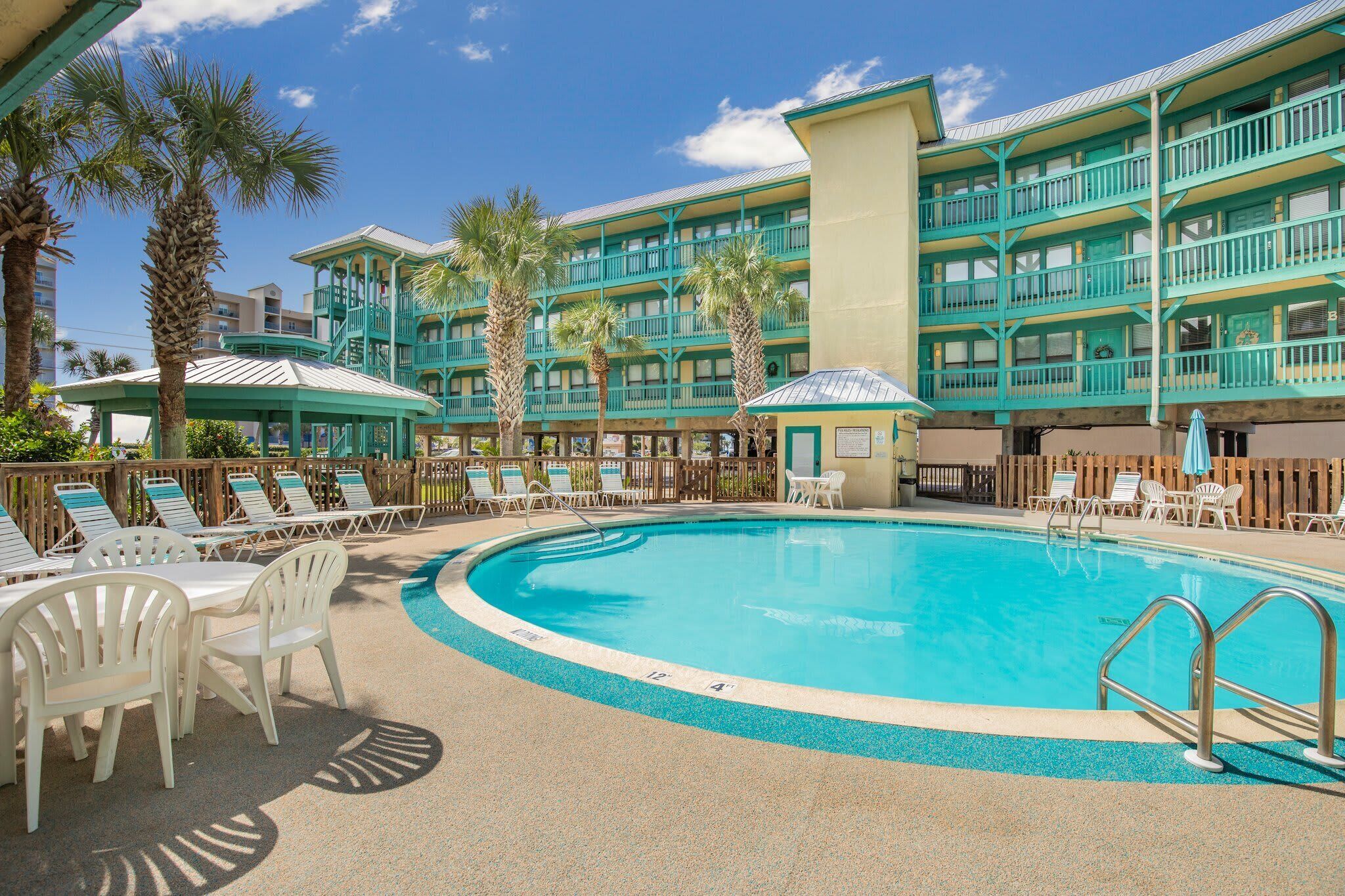 Ein Poolbereich eines Resorts mit mehreren Liegestühlen und einem Pool.