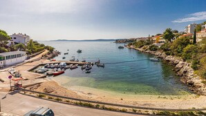 A coastal marina with boats docked, a sandy beach, and buildings along the shore. - Stunning apartment in Okrug Gornji with WiFi (Okrug Gornji)