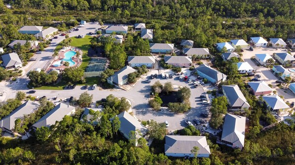Luchtbeeld van een resort met meerdere gebouwen, een zwembad en een centrale binnenplaats.