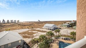 A beachfront property with multiple houses, a pool, and a sandy beach.
