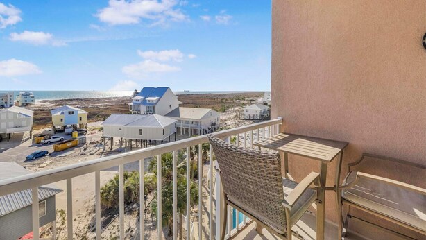 A balcony with a view of a beach and houses.