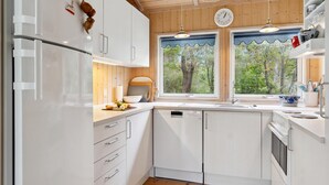A modern kitchen with white cabinets, a refrigerator, a sink, and a window with a view of trees. - 3 bedroom lovely home in Nykøbing Sj (Nykøbing Sj)
