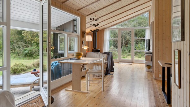 A spacious room with a large wooden ceiling, a dining area with a table and chairs, a television, and a fireplace. - 3 bedroom lovely home in Nykøbing Sj (Nykøbing Sj)