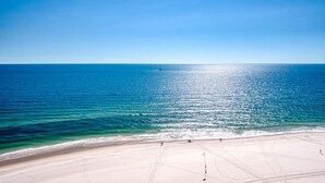 Une plage avec un ciel dégagé et une mer calme.