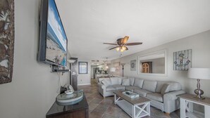 A spacious living room with a large gray sectional sofa, a wooden coffee table, and a ceiling fan. -   🌊Gulf Front Condo with Amazing Views-Ocean House 2604🌊 (Gulf Shores)
