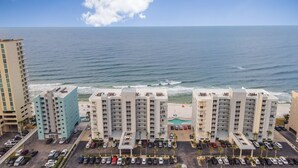 A beachfront hotel with multiple buildings, a parking lot, and a view of the ocean. - 🌊Gulf Front Condo with Amazing Views-Ocean House 2604🌊 (Gulf Shores)