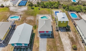 Zona residencial con varias casas, cada una con piscina.