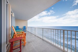 A balcony with a view of the ocean, featuring a railing and a few colorful chairs. - 🌊🏖️ San Carlos 1604 | Renovated Gulf Front | Pool + Steps to The Hangout (Gulf Shores)