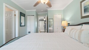 A bedroom with a large bed, a ceiling fan, and a nightstand with a lamp. - 🐶Pet Friendly Condo with Pool-Steps to the Beach-Sea & Sun 204🌴 (Gulf Shores)