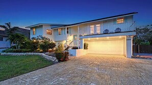 A two-story house with a garage, a balcony, and a well-maintained garden.