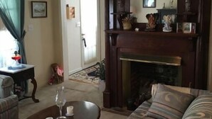 Ein Wohnzimmer mit einer Couch, einem Couchtisch, einem Kamin und einer Chandelier.