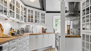 A modern kitchen with white cabinetry, a wooden countertop, and a stainless steel range hood. - Stunning home in Hurup Thy with WiFi (Hurup Thy)