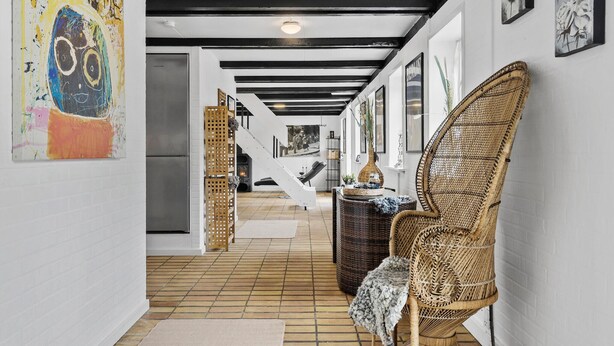 A hallway with a staircase leading to a second floor, wicker furniture, and a fireplace. - Stunning home in Hurup Thy with WiFi (Hurup Thy)
