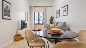 A modern living room with a round table, sofa, and a television. - In downtown Funchal, Tanoeiros Residence II (Funchal)