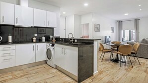 Una cocina moderna con una isla central, electrodomésticos integrados y un comedor con vistas.