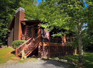 A log cabin with a wooden staircase, a deck, and an American flag. - Cabin with a Creek   Screened porch.  Pet Friendly (Blue Ridge)