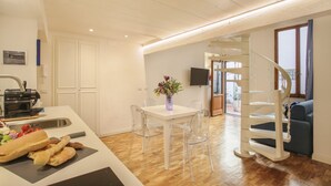A modern kitchen with a dining area, a staircase, and a view of the outdoors. - Cinque Passi - Sweet Dreams in Florence (Firenze)