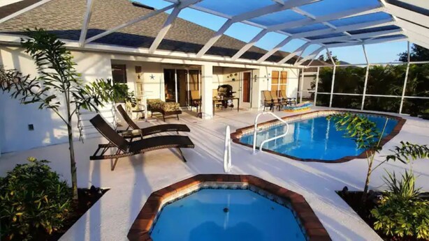 Uma área de piscina descoberta coberta, com espreguiçadeiras e um terraço.