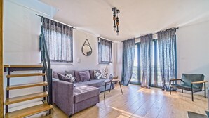 A modern living room with a sofa, a chair, a table, and a staircase. - Nice home in Ivancici with house a mountain view (Ivancici)