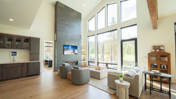 Amplia sala de estar con cocina, ventanas grandes y muebles modernos.