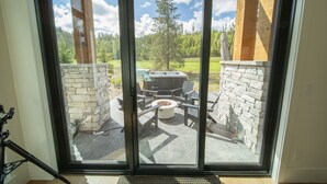 Un patio con muro de piedra, un hogar para fuego y mobiliario exterior.