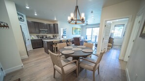 A spacious kitchen with dark cabinets, a central island, and a dining area with a round table and chairs. - Clearwater Lofts Bldg 2 303 (Keystone)