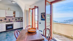 A kitchen with a dining table, chairs, and a view of the sea. - Amazing home in Recco with WiFi (Recco)