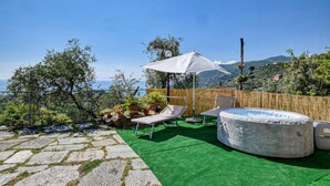 A rooftop patio with a hot tub, lounge chairs, and a view of the sea. - Amazing home in Recco with WiFi (Recco)