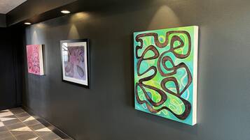 A hallway with three framed artworks on the wall.