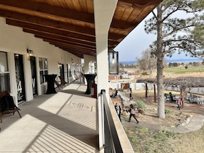 A covered patio area with outdoor seating and a view of the surrounding landscape.